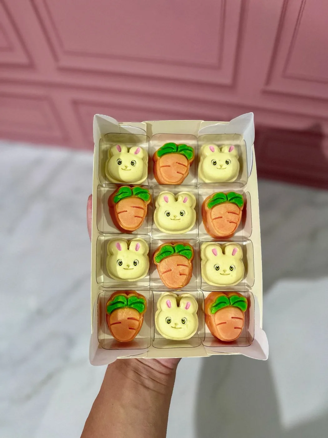 Caixa com doces personalizados em formato de coelho e cenoura.