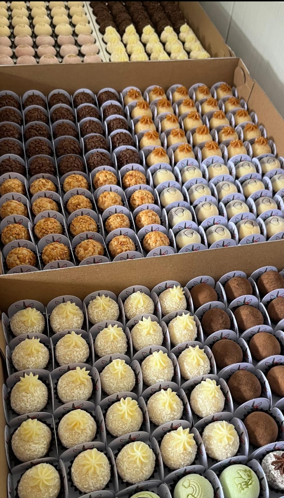 Bandejas com brigadeiros organizados para produção.