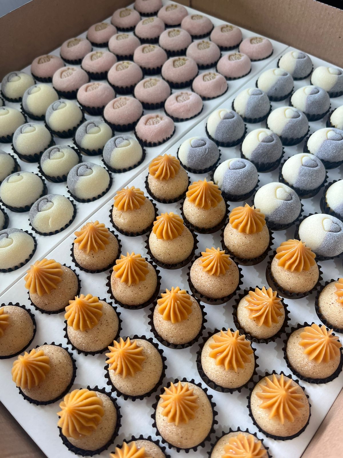 Brigadeiros sortidos com acabamentos variados em bandeja.